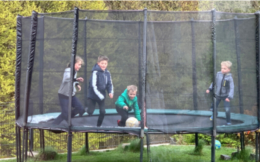 Kinder spielen auf Trampolin mit Sicherheitsnetz